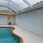 shuttered doors and porch by screened in pool area